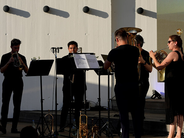 fünf MusikerInnen mit Blechblasinstrumenten vor weißem Hintergrund