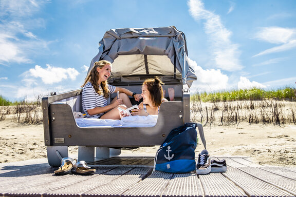 Schlafstrandkorb am Strand von Norderney mit zwei jungen Frauen